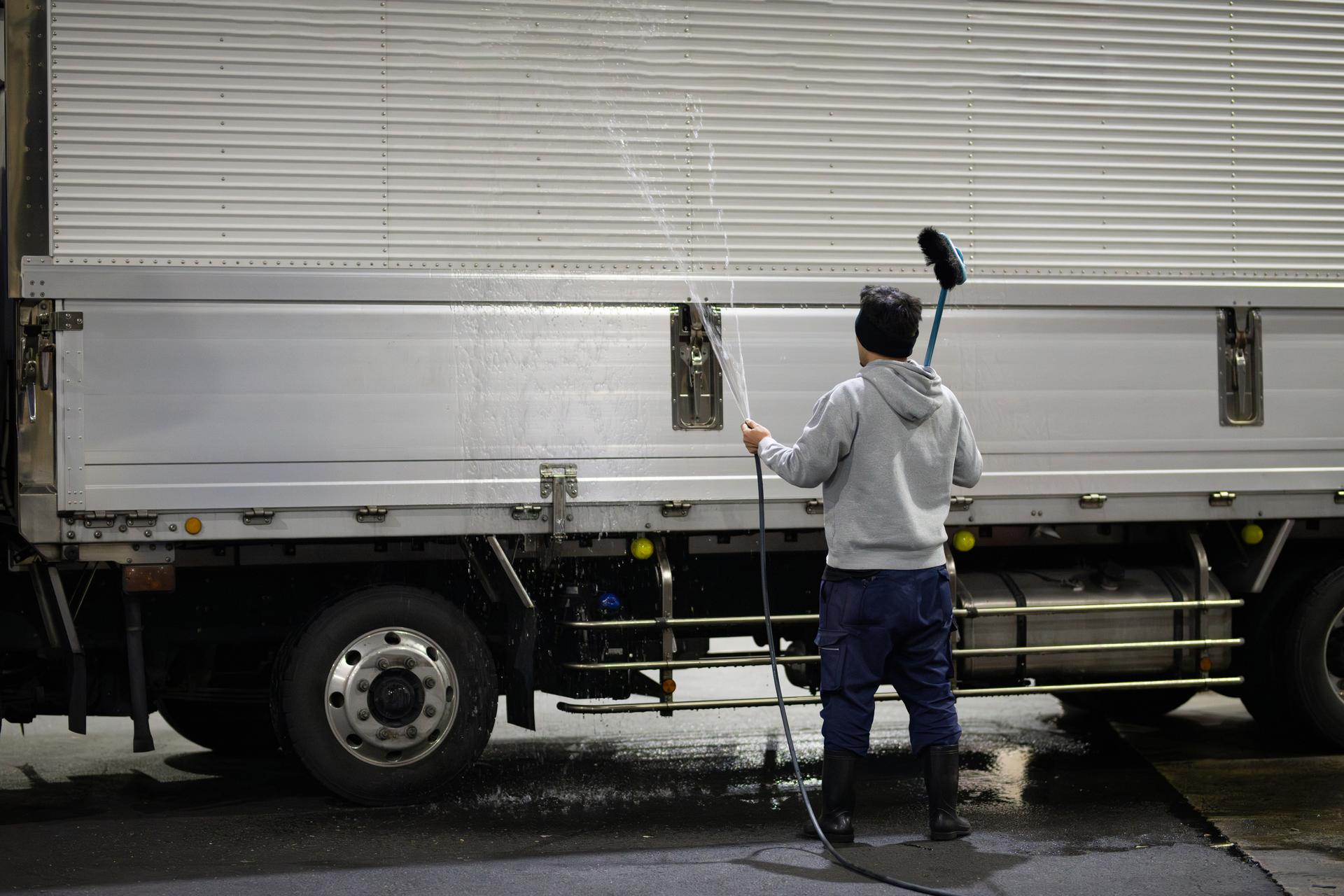 A man washing a large truck