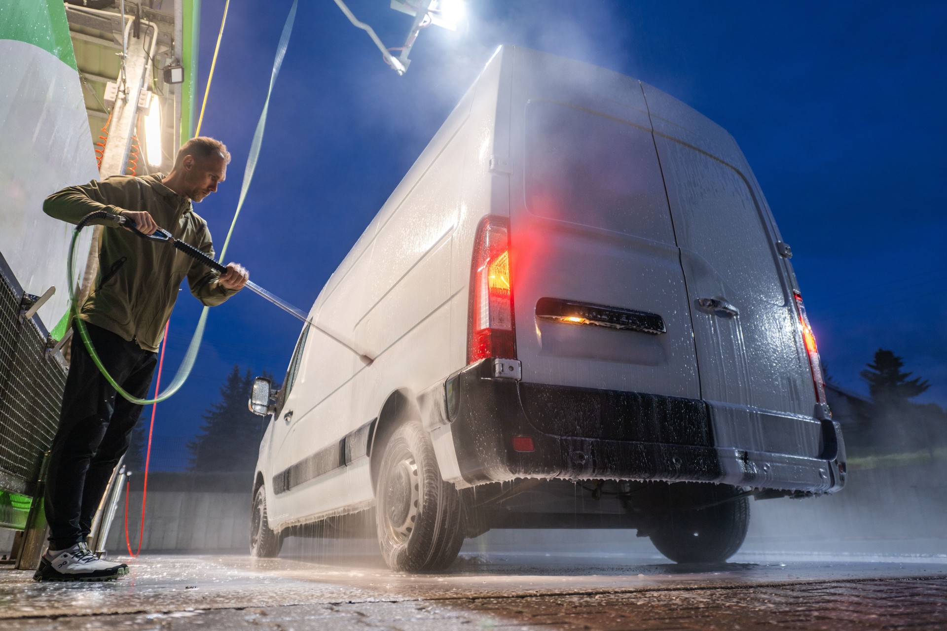 Man Washing White Cargo Van at Night